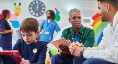 doctor with parent in children's hospital reception discussing medicine