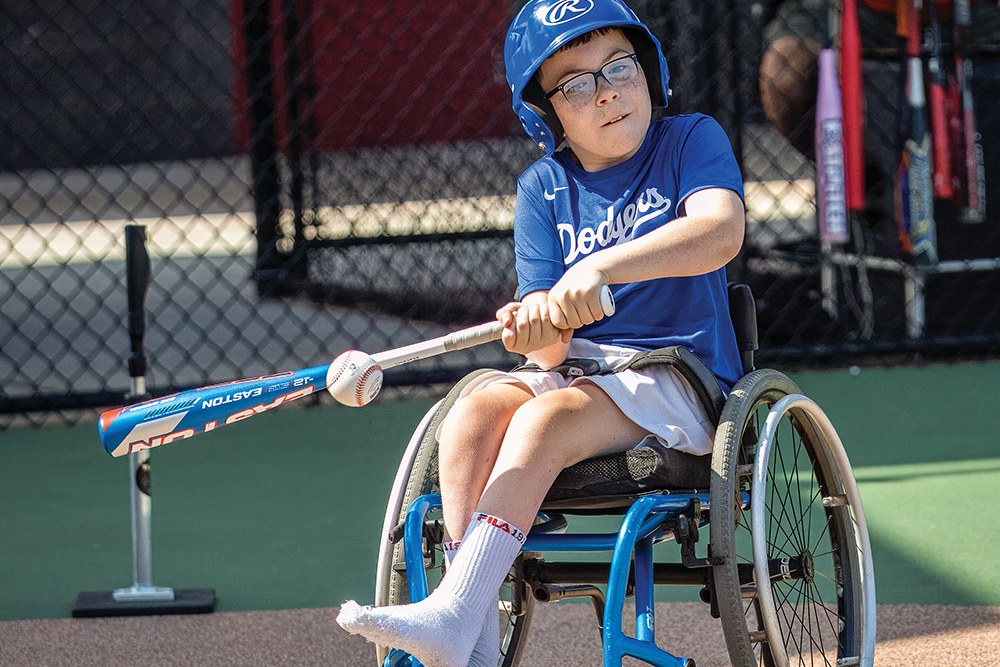 A child hits a baseball from his wheelchair. The Miracle League is a nationwide organization that provides a way for children with disabilities to play organized baseball.