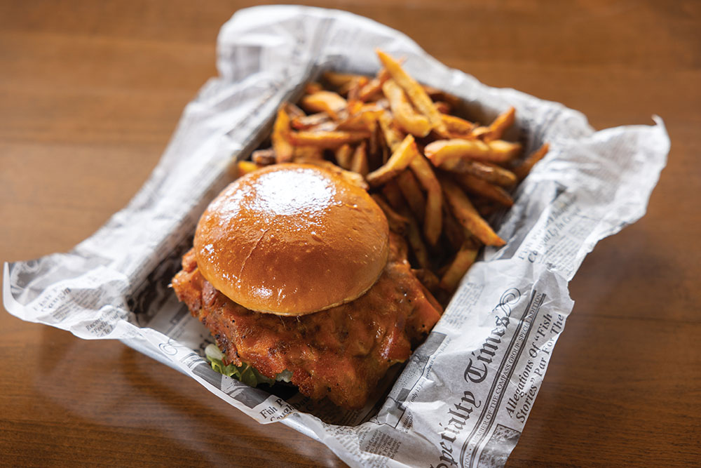 The Cheese Crust Smashburger is made with cheddar cheese, lettuce, tomato, Print Sauce, house-made spicy garlic pickles and served with fries at The Print Shop Restaurant in Smyrna, Tennessee.