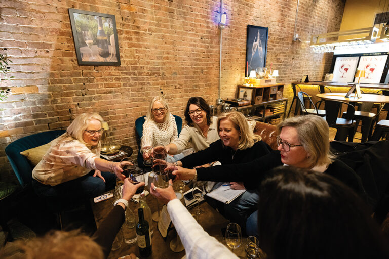 A group of friend toast while visiting at Hemispheres Wine Bar in downtown Murfreesboro, TN.