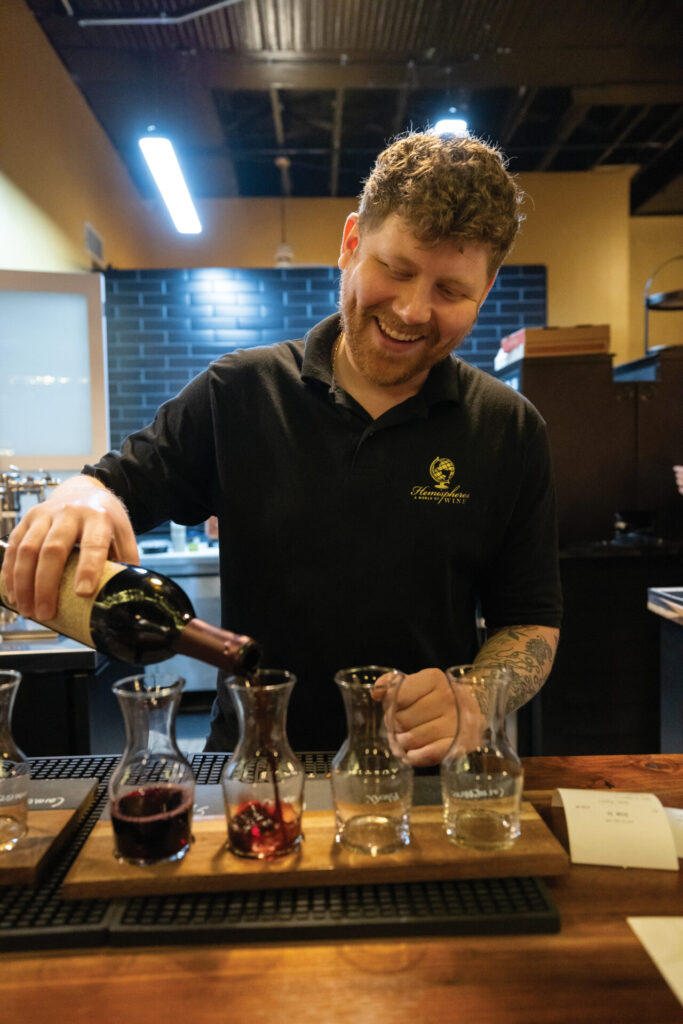 Trey Warden pours wine flights for customers at Hemispheres Wine Bar in downtown Murfreesboro, TN.