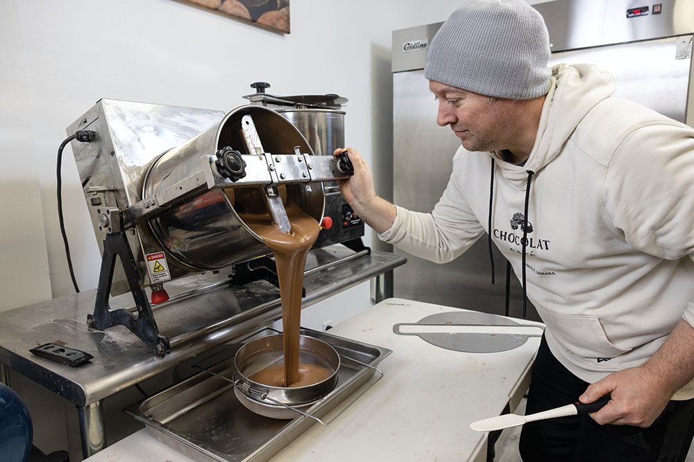 Dustin Cornett makes a batch of chocolate for Valentine's Day at Chocolat Cafe in Rushville, Indiana.