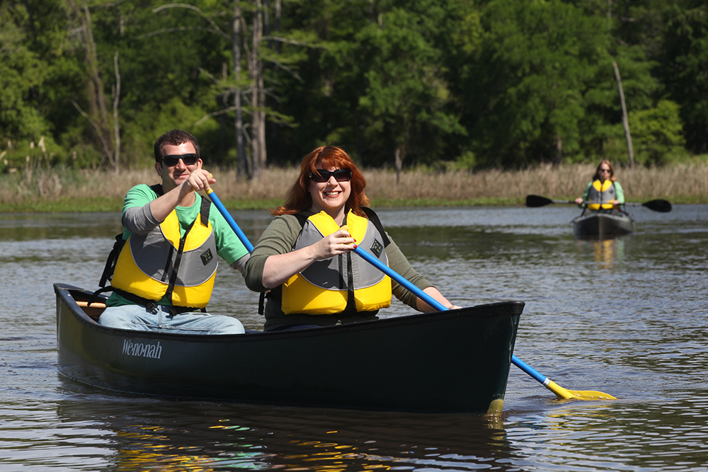 People paddle canoes and kayaks on the Bayou Bartholomew Water Trail in Arkansas.