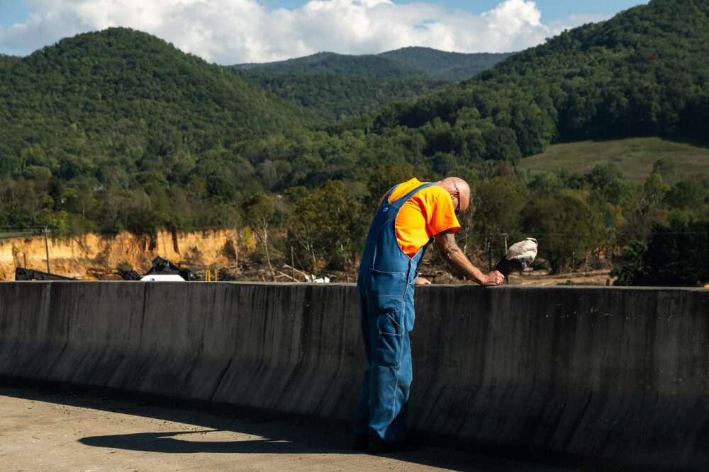 October 5, 2024 - Erwin, TN A man praying along the Jackson Love Highway bridge that crosses the destruction of I-26 in Erwin, TN from Hurricane Helene Disaster.