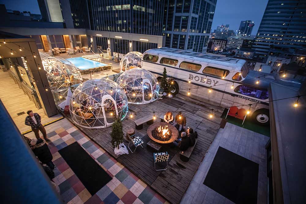 Visitors enjoy drinks around a campfire at the Camp Bobby winter pop-up on the roof of the Bobby Hotel in downtown Nashville, Tennessee. The Bobby Hotel is just one of many spots in Tennessee serving up fresh food.