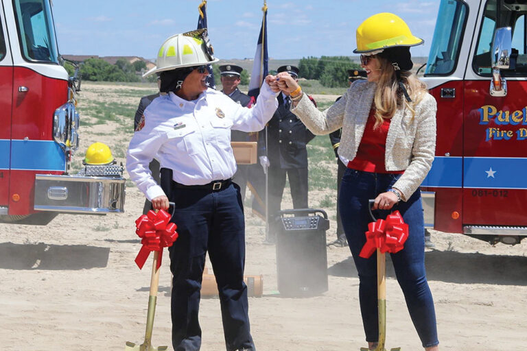 Pueblo Mayor Heather Graham bumps fists with a local fire official at a groundbreaking event.