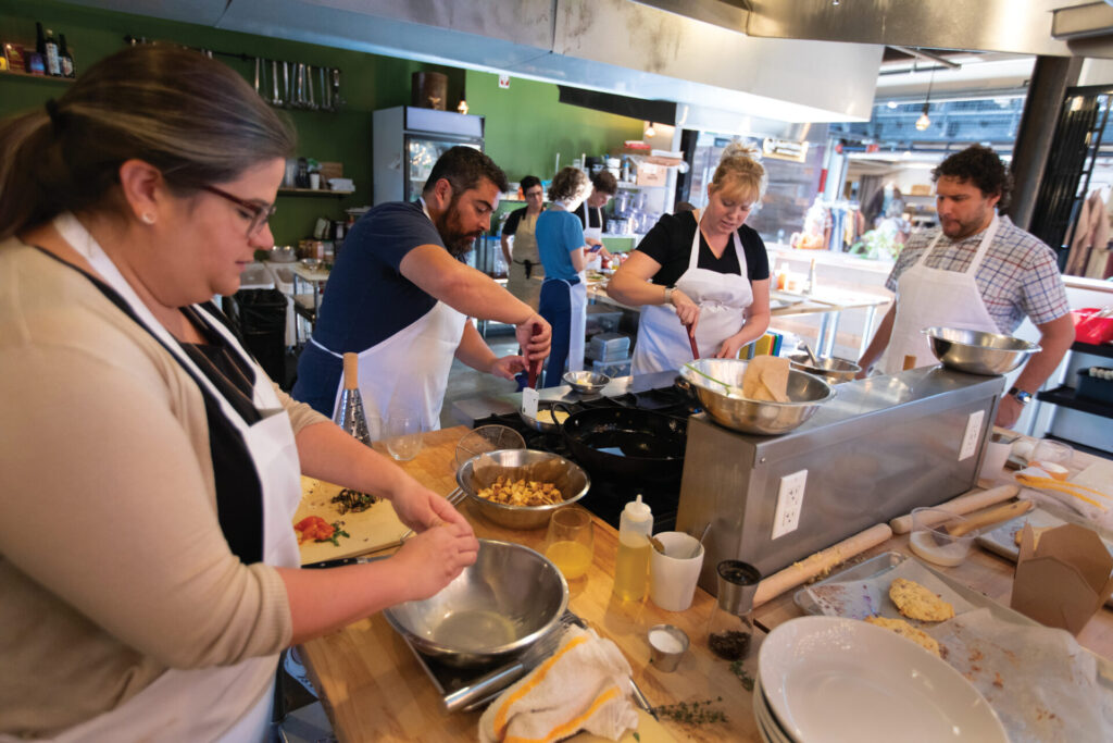 Students learn to cook at Create Cooking School at Create Kitchen and Bar at Stanley Marketplace in Adams County, Colorado.