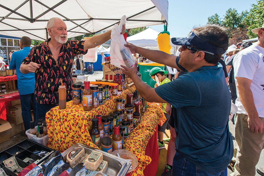 A customer buys hot sauce at the Pueblo Chile Festival in Pueblo, CO.