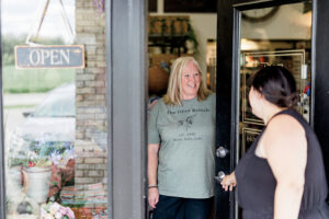Owner Kris Richey greets a customer at The Olive Branch boutique in Council Bluffs, IA.
