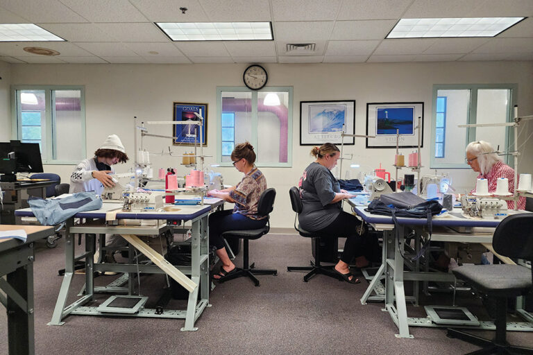 Students sew at work tables in the industrial sewing at Pueblo Community College in Pueblo, CO. 