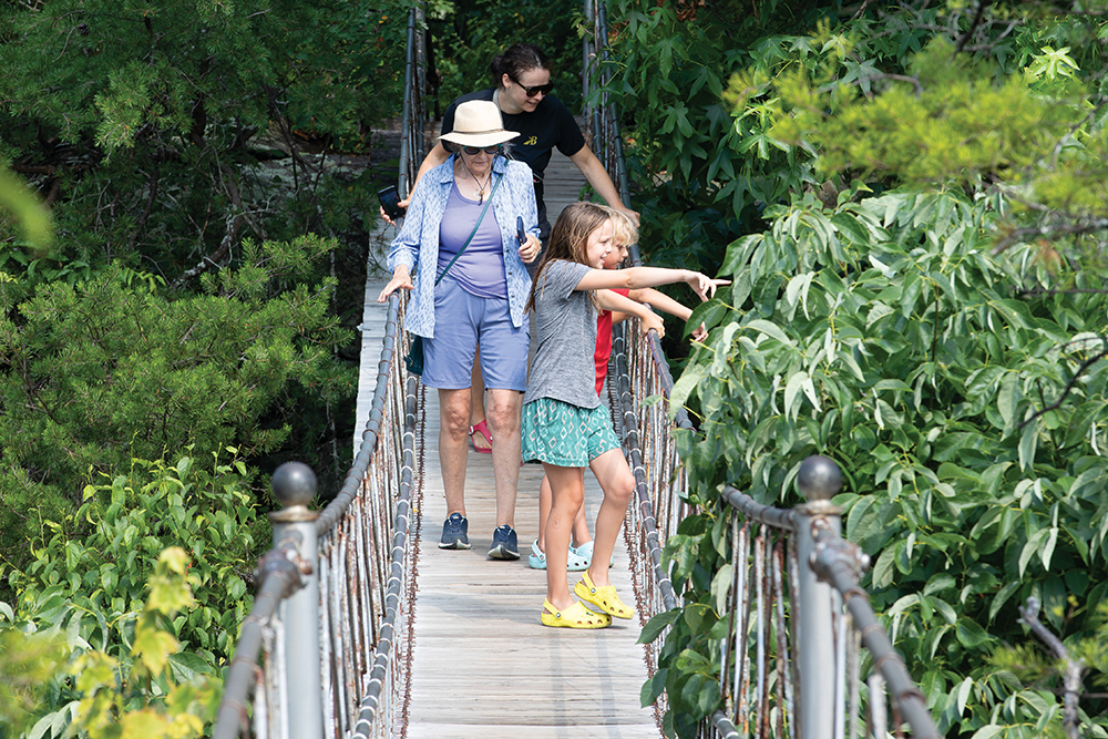 People cross the swinging bridge at the Rock City Gardens at Lookout Mountain in Chattanooga, TN.