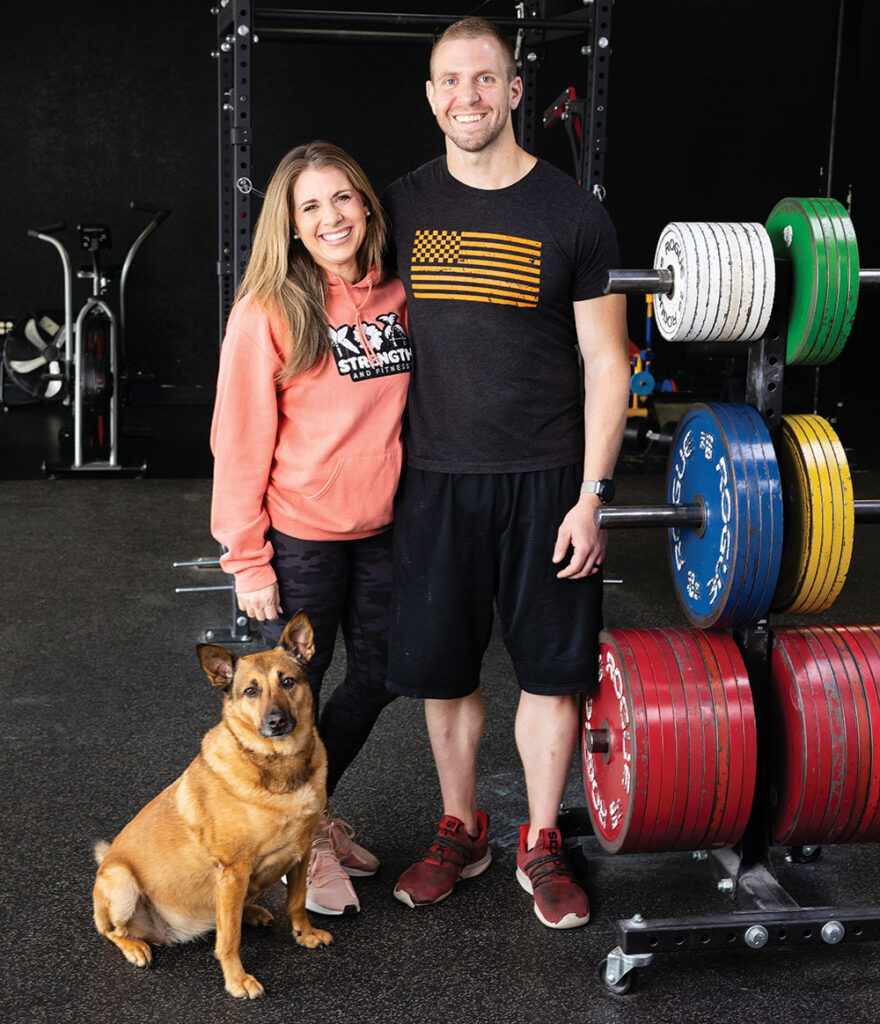 Kelley and Pete Rubish, owners of Koa Strength and Fitness, work at the gym with their dog, Atlas.
