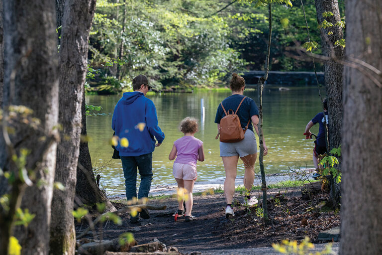 A family hikes along the water's edge at Locust Lake State Park in Schuylkill County, PA.
