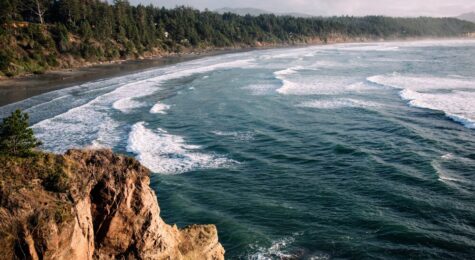 Aerial drone footage from the coast of the Pacific Northwest, featuring Oregons beautiful rugged terrain and blue ocean waves. Captured at Otter Rock near Lincoln City, Oregon, USA.