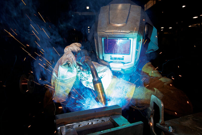 Komatsu pre-apprenticeship program student Samuel Herron works on a welding station in Komatsu America Corporationís manufacturing plant in Chattanooga.