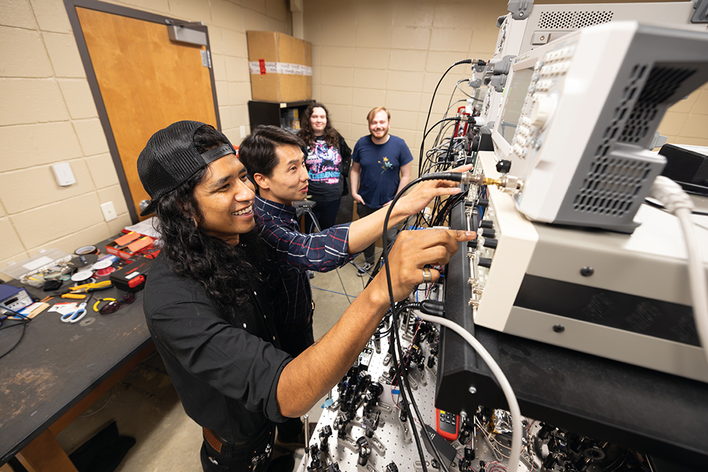 Assistant Professor of Physics Tian Li, Ph.D. (plaid shirt) works with students in a lab The Quantum Center at UT Chattanooga, in Chattanooga, Tennesssee.
