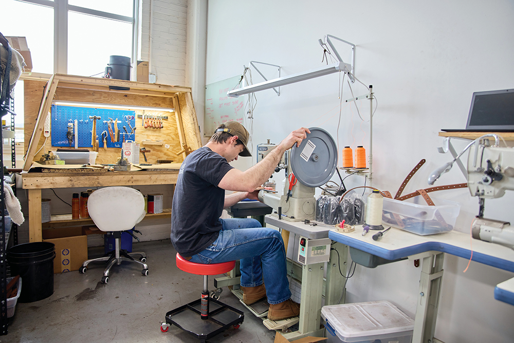 A man works on a sewing machine in the manufacturing space at the INCubator at the Hamilton County Business Development Center.