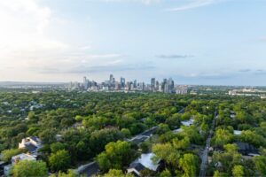Aerial perspective of Austin, Texas skyline emerging above a verdant tree cover in a residential area, highlighting city's mix of urbanization and natural allure stock photo