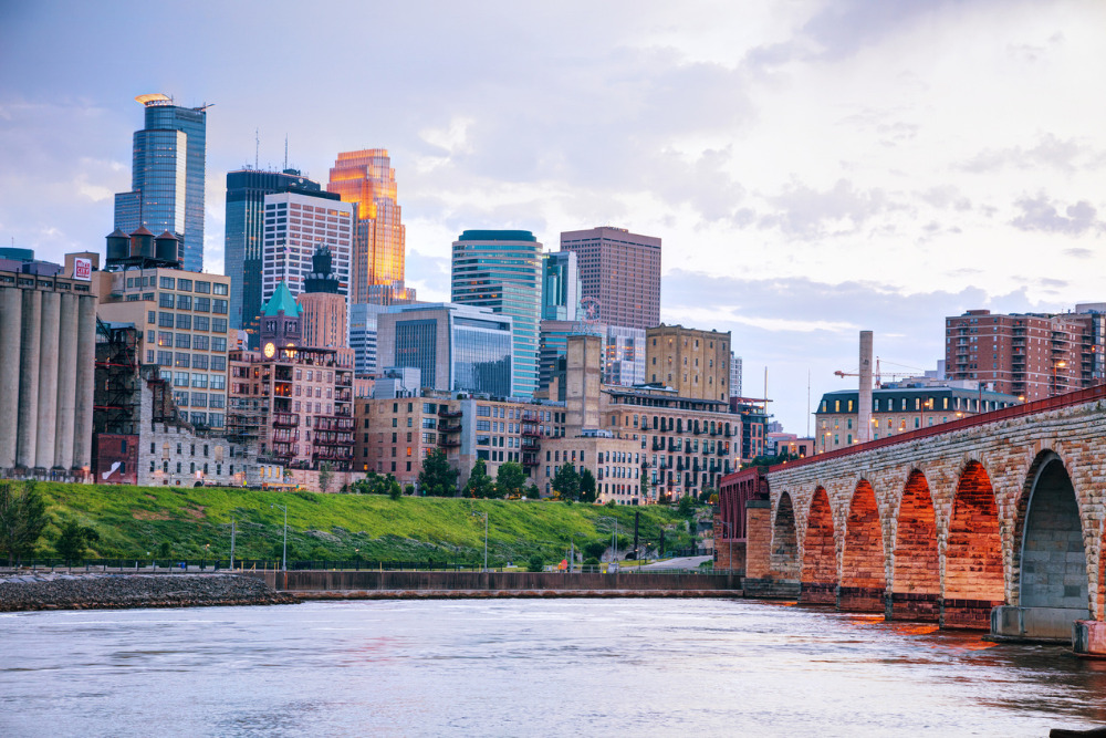 Downtown Minneapolis, Minnesota at night time as seen from the famous stone arch bridge.