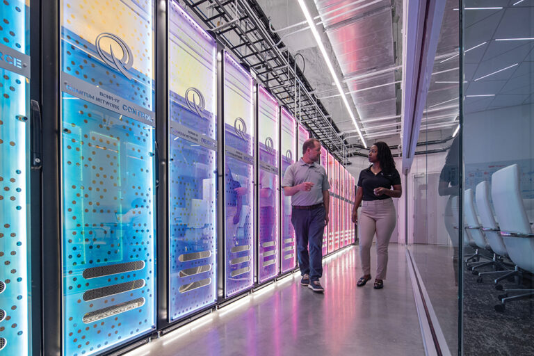 A man and woman walk inside the quantum network control room at EPB.