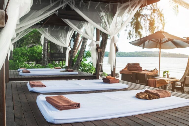 Massage mats laid out with a beach view at a spa. Whole body wellness is a booming business with options ranging from hot springs and forest bathing to wellness retreats.