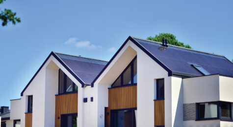 Terraced family homes in newly developed housing estate. The real estate market in the suburbs. New single family houses in a new development area. Residential homes with modern facade.