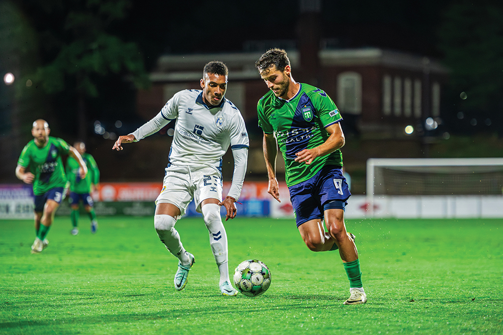 Greenville Triumph SC (green jerseys) play soccer.