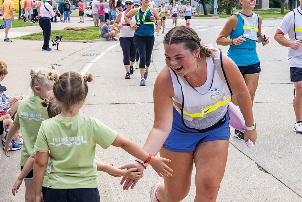 A young woman slaps hands with three little girls as she passes them during the St. Jude Run.