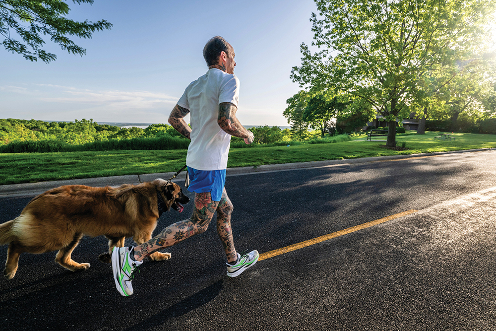 Adam White, owner of RC Outfitters in Peoria, IL, goes for a run with his dog.