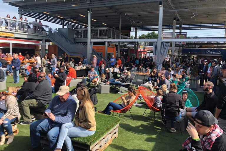 Customers gather to enjoy food and drinks at Gather GVL food hall in Greenville, SC.