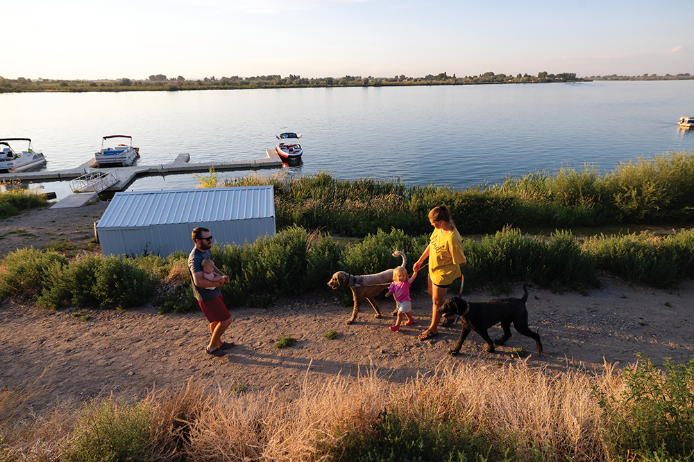 Visitors enjoy time in the water next to the boat slips at The Boathouse at Riverside Resort and RV Park in Burley, Idaho, a Harvest Hosts location.
