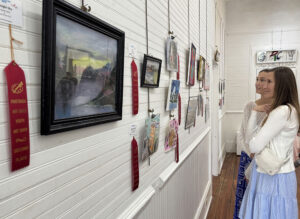 Two women admire the winning entries of an arts show.
