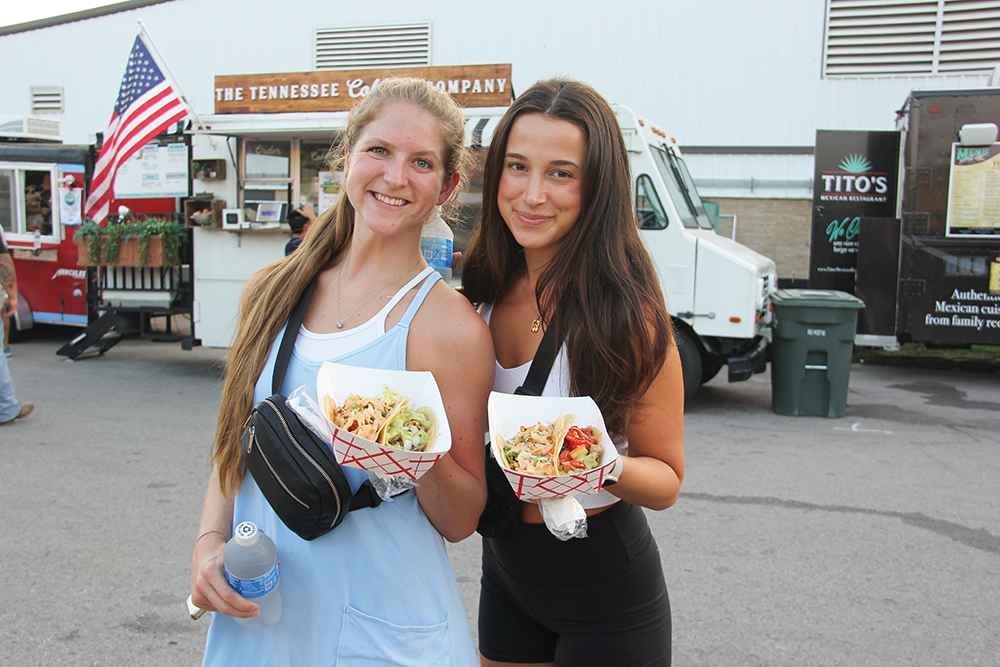 Two young women pose for a photo with plates of tacos at Williamson County Fair in Franklin, TN.