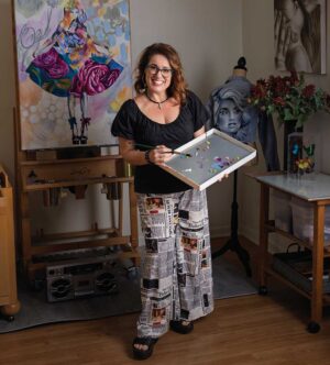 Graffiti artist Shen holds a palette of oil paints while working on one of her paintings in her home studio in Madison, Tennessee. Her official artist name is ShenShen210.