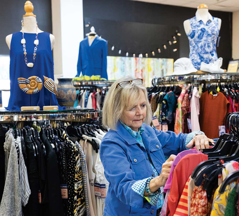 Volunteers hangs clothes on display racks in the boutique at GraceWorks Ministries in Franklin, Tennessee.