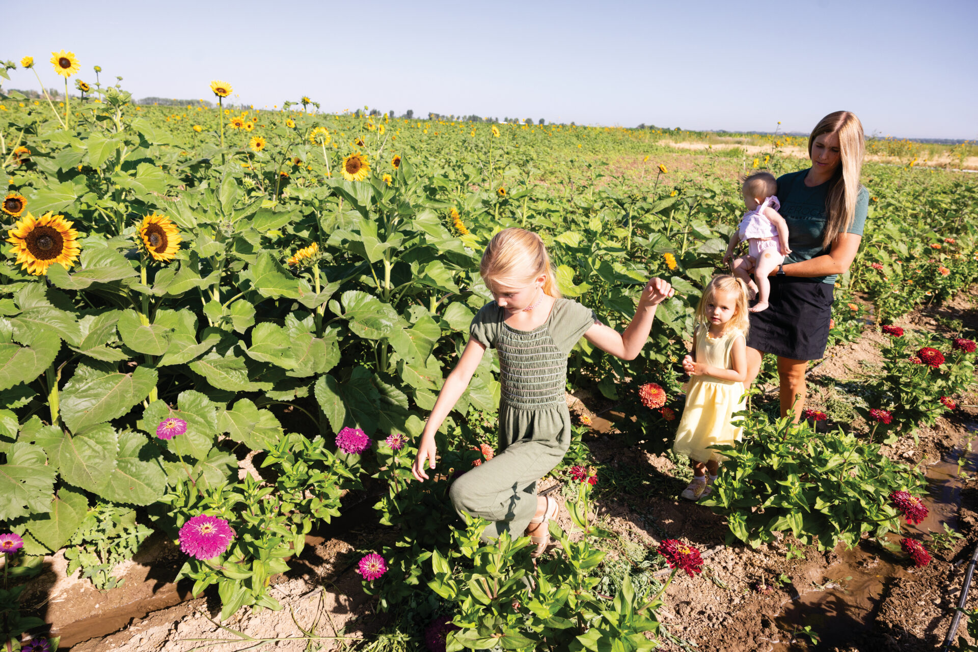 Ashley Brown with her daughters, Addy, 6, (green) Ella, 4, (yellow) and Raleigh, 7 months check out the flower garden at BlueRock Farm Market in Twin Falls, Idaho.
