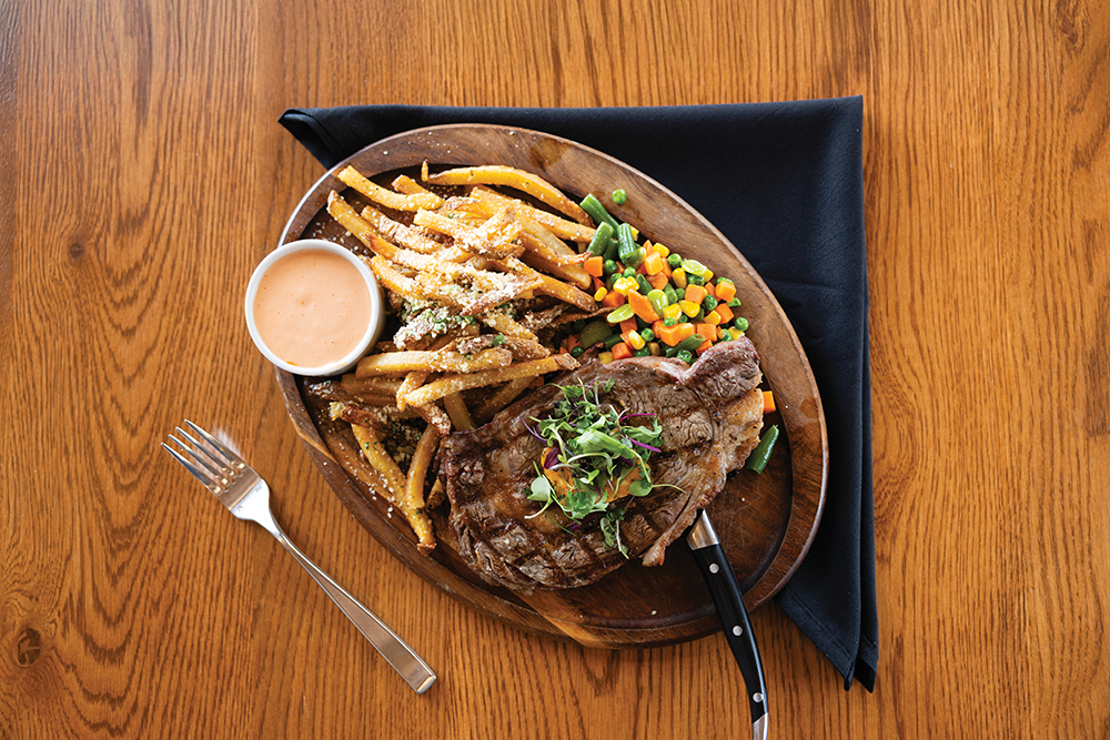 The grilled ribeye steak with garlic parmesan fries and mixed vegetables at Edgewater Dining & Spirits in Burley, Idaho.