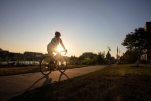 Person rides a bike along the Cedar River Bike Trail at dusk.
