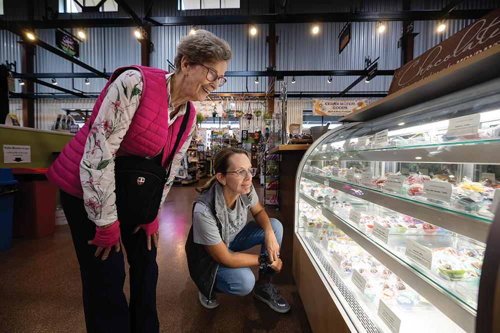 Emma Graham Taylor, in gray, looks at candies with her mother Sarah Hill at Lorii Annís Candies at the NewBo City Market in Cedar Rapids.