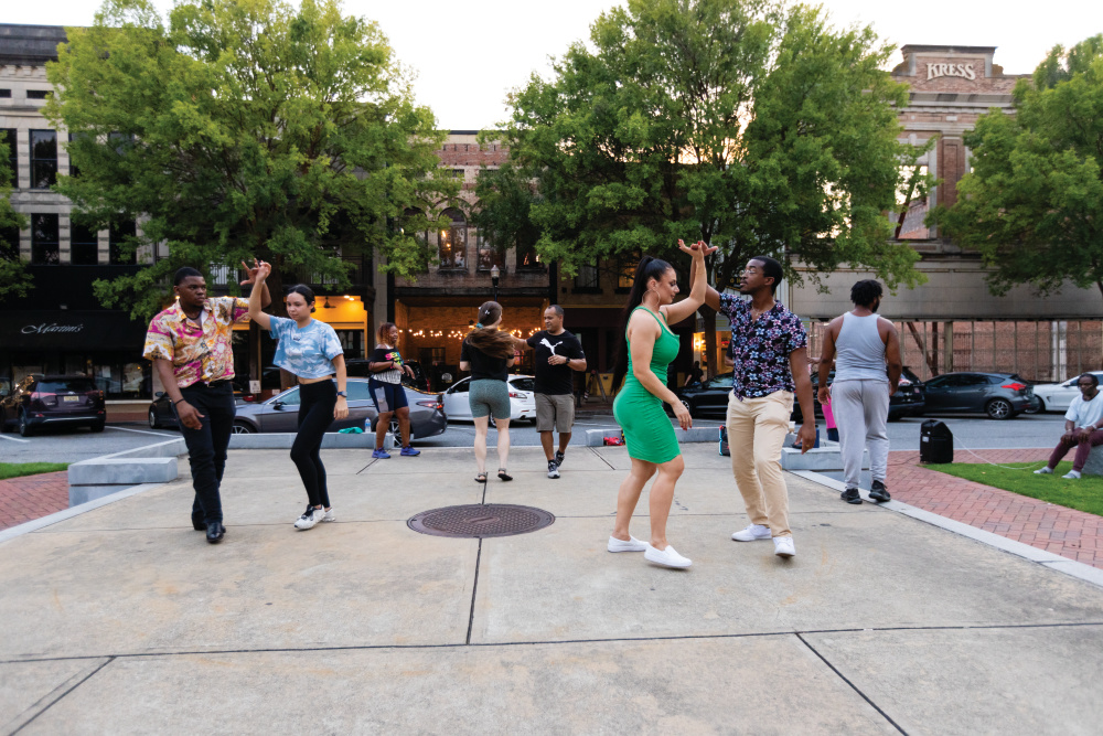 Dancers practice in the courtyard in the middle of Broadway at dusk in downtown Columbus, Georgia.