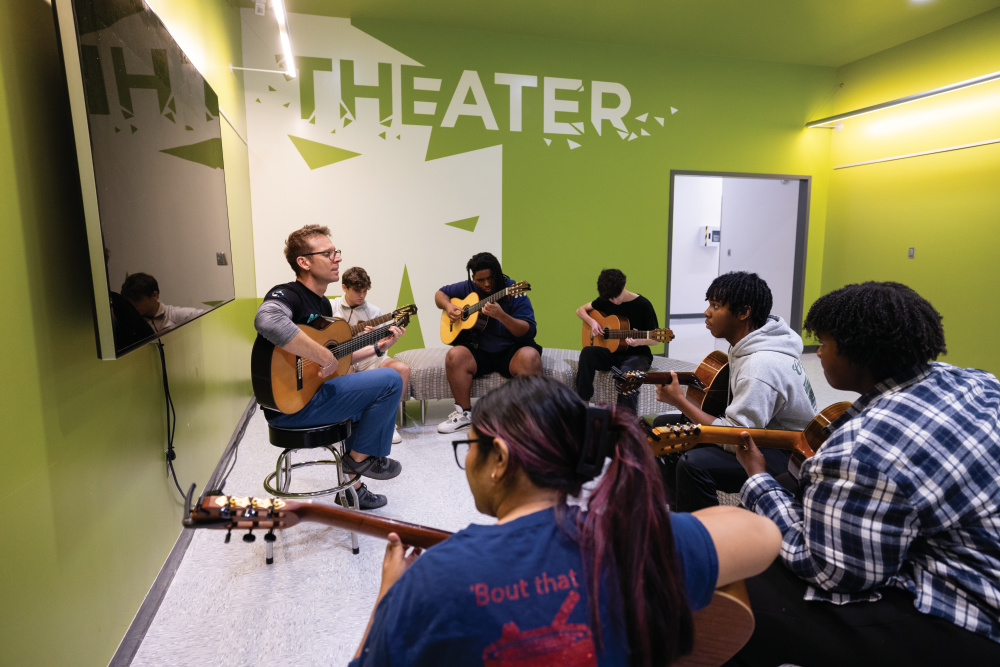 Michael Gratovich teaches students a guitar technique at the Rainey-McCullers School of the Arts in Columbus.