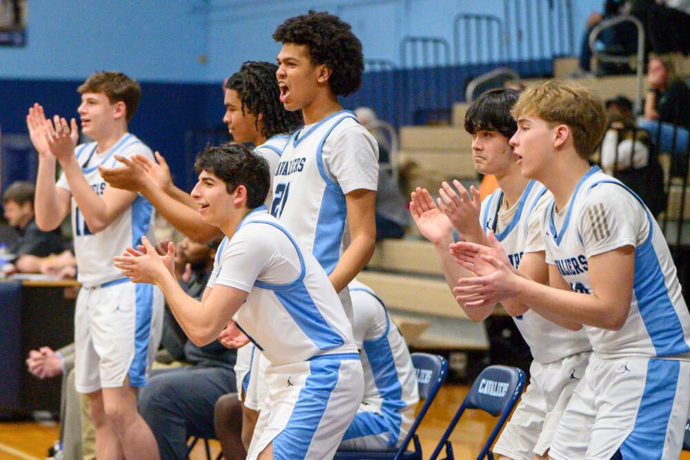 CCES basketball players cheer their teammates from the sidelines.