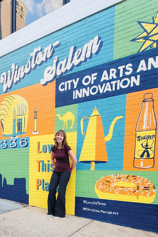 Artist Christina Parish poses in front of one of Winston-Salem's many murals.