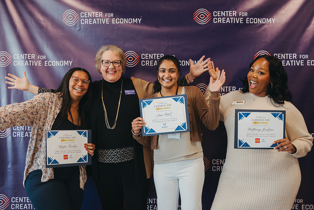 Four women pose with awards from the Center for Creative Economy in Winston-Salem, NC. The center provides entrepreneurial resources to new businesses in the region.