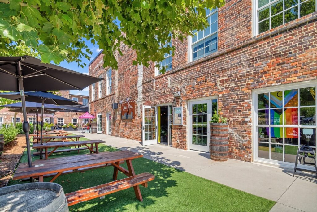 Optimist Food Hall in Charlotte, NC, has a large outdoor dining area with picnic tables.