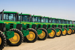 A row of John Deere farm tractors wait to be sold to the highest bidder at a Ritchie Bros Auction.
