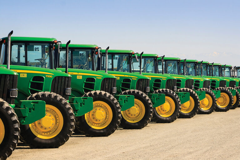 A row of John Deere farm tractors wait to be sold to the highest bidder at a Ritchie Bros Auction.