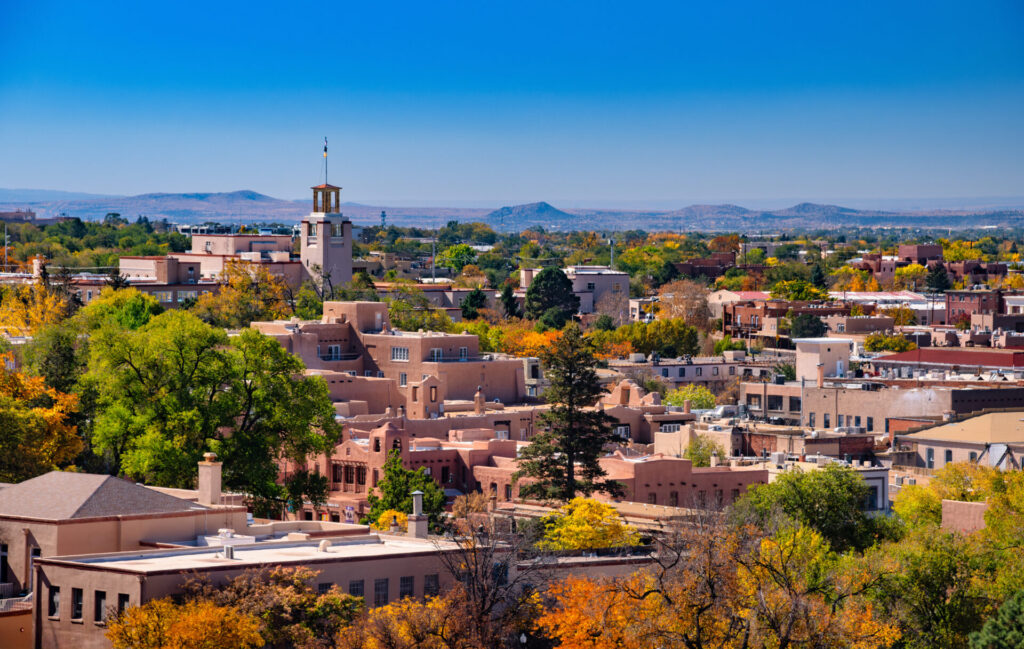 Downtown Santa Fe skyline view during Autumn, with a beautiful variety of autumn colors on lush trees all around.