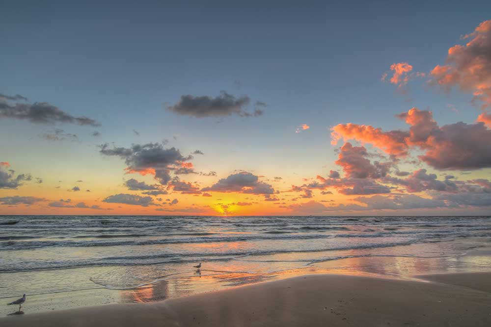 Sun sets over the water at South Padre Island, Texas — a great place to maximize your PTO for 2026.