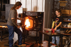 Mike Tracy and student Taylor Greene make a glass turkey during a demo for a public audience at ECU GlasStation in Farmville, NC.